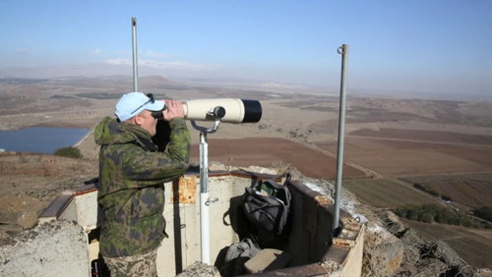 A United Nations observer looks through binoculars at a lookout point on Mount Bental in the Israeli Golan Heights, near the border with Syria, in December 2016. Credit: Yossi Zamir Flash90.