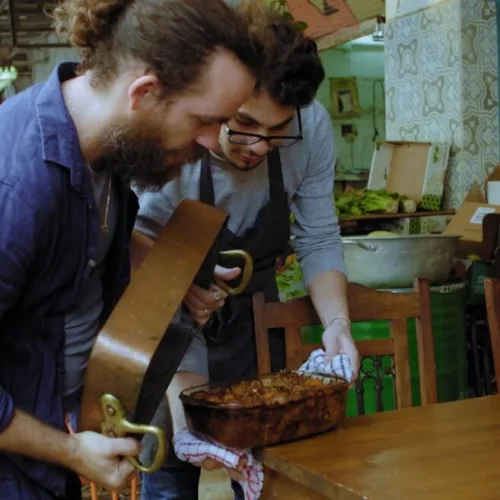 Chefs Ilan Ferron and Osama Dalal prepare to flip octopus maqluba in a scene from “Breaking Bread.” Photo courtesy of Cohen Media Group.