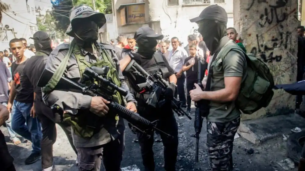 Palestinian gunmen near a damaged house following an Israeli military raid at the Nur Shams refugee camp, east of Tulkarm, on Sept. 5, 2023. Photo by Nasser Ishtayeh/Flash90.