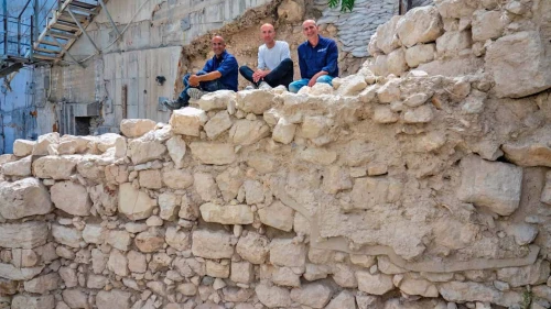 The wall of Jerusalem as uncovered in the excavations of the Israel Antiquities Authority, with, from left, Ortal Chalaf, Dr. Filip Vukosavovich and Dr. Joe Uziel. Photo by Kobi Harati/City of David Foundation.