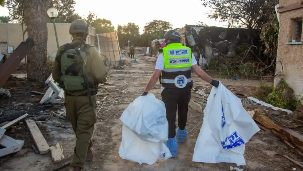 A member of Israel's ZAKA search-and-rescue organization searches for human remains in Kfar Aza, near the Israeli-Gaza border in southern Israel, Oct. 15, 2023. Photo by Edi Israel/Flash90.