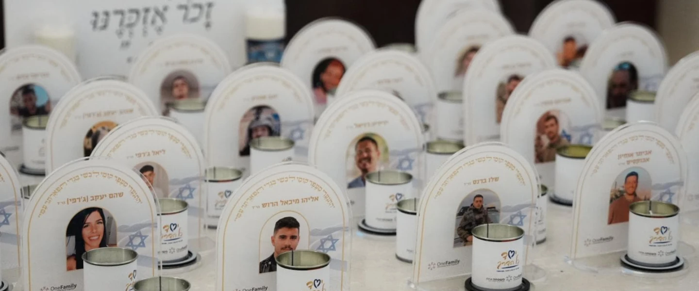 Memorial candles in front of images of the fallen at the OneFamily Passover weekend. Photo by Meir Pavlovsky.