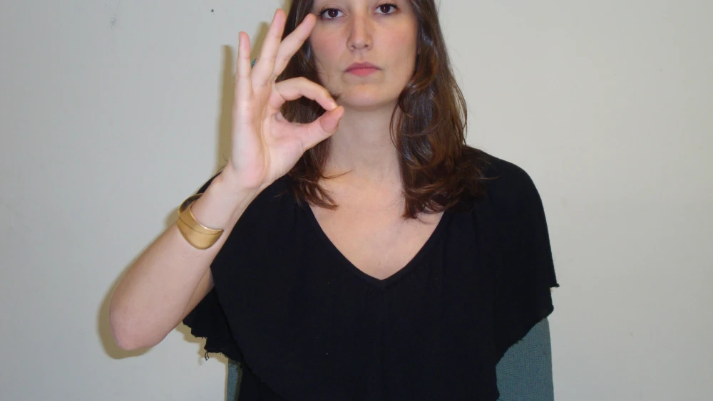 A woman giving the OK hand gesture. Credit: Wikimedia Commons.