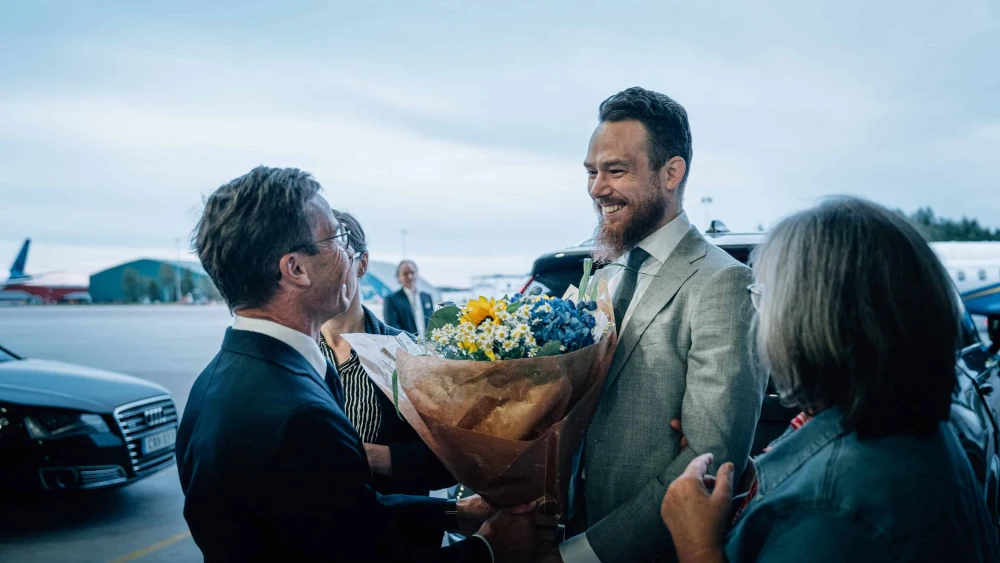 Swedish citizen Johan Floderus (right) is greeted by Swedish Prime Minister Ulf Kristersson upon his arrival at Arlanda airport near Stockholm, on June 15, 2024. Photo by Tom Samuelsson/TT News Agency/AFP via Getty Images.