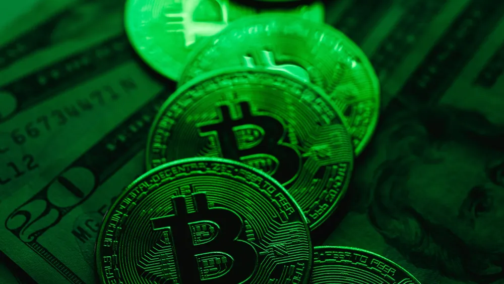 A stack of Bitcoin coins on top of U.S. dollar bills. Credit: Karolina Grabowska/Pexels.