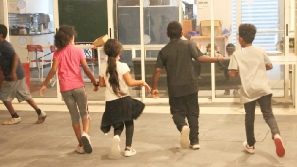 Children in the afterschool program of Afikim in Jerusalem practice running “blind” with a running guide, an activity led by blind Israeli-Ethiopian marathon runner Avi Solomon. Photo by Judith Sudilovsky.
