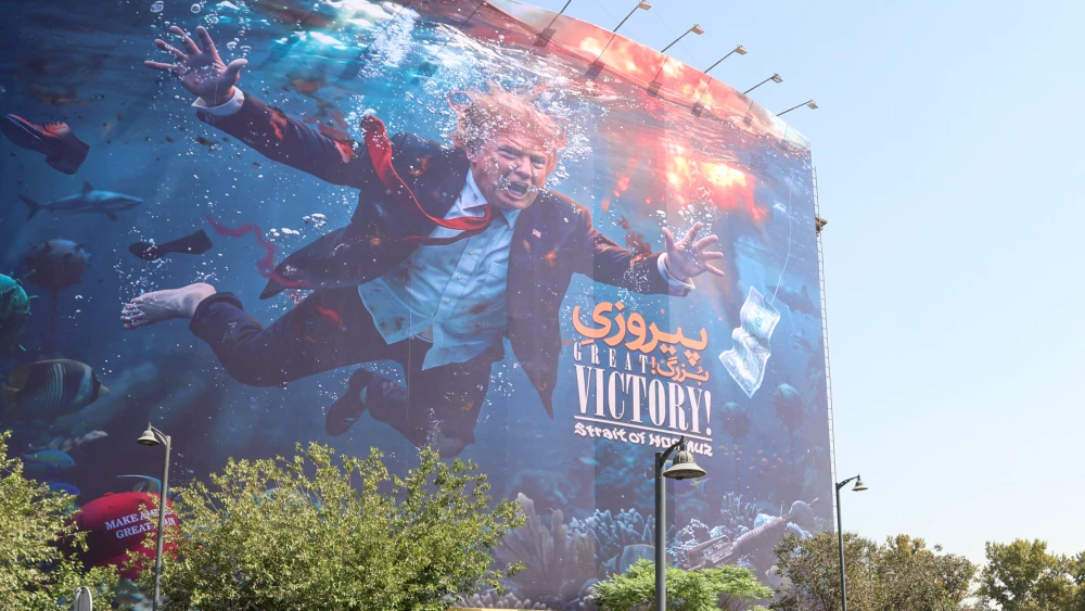 Two women walk past an anti-U.S. billboard in Tehran on August 24, 2026. Photo by AFP via Getty Images.