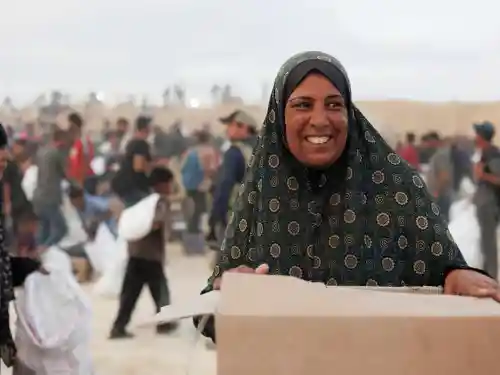 A Palestinian woman receives a food package from the Gaza Humanitarian Foundation in Gaza, June 2025. Credit: Gaza Humanitarian Foundation.