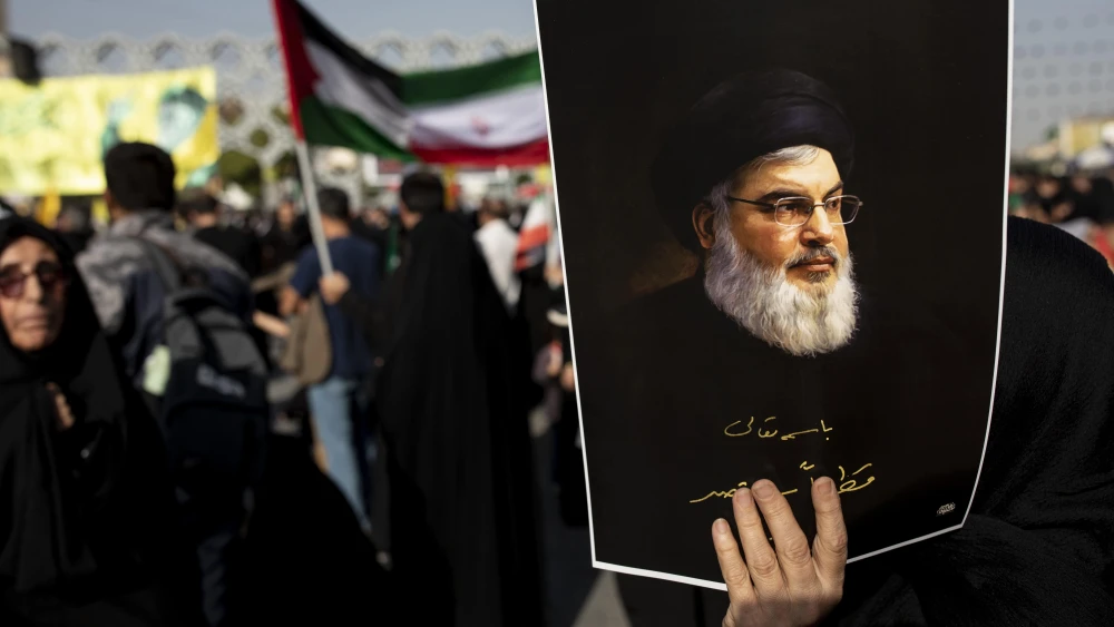 An Iranian demonstrator carries a poster of slain Hezbollah leader Hassan Nasrallah in a rally in Tehran commemorating him, Oct. 2, 2024. Photo by Majid Saeedi/Getty Images.