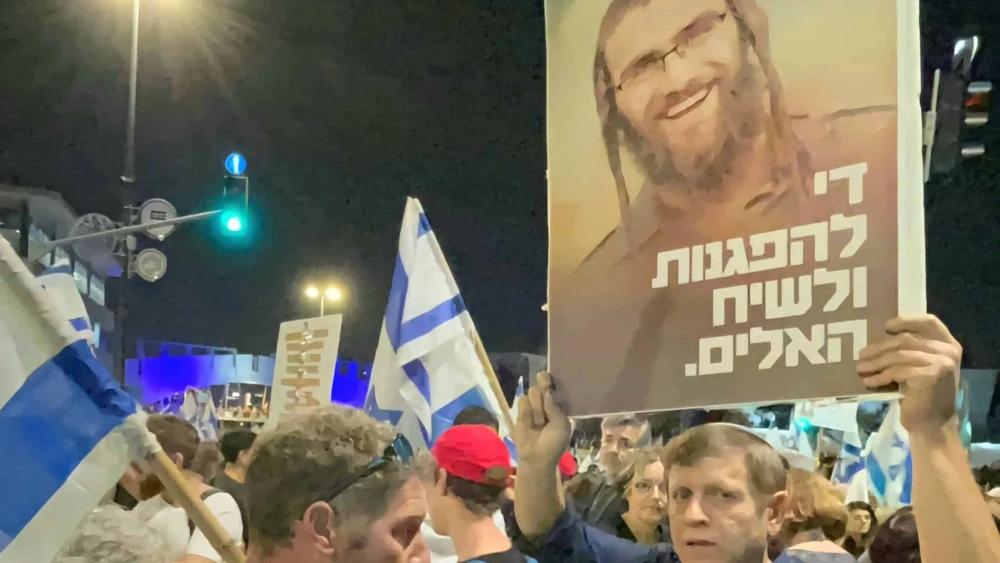 Hagay Lober holds a placard in Jerusalem depicting his son Staff Sgt. (res.) Elisha Yehonatan Lober, who was killed action in Gaza in December, and reading, "Enough of the demonstrations and the violent discourse, March 31, 2024. Source: Social media.
