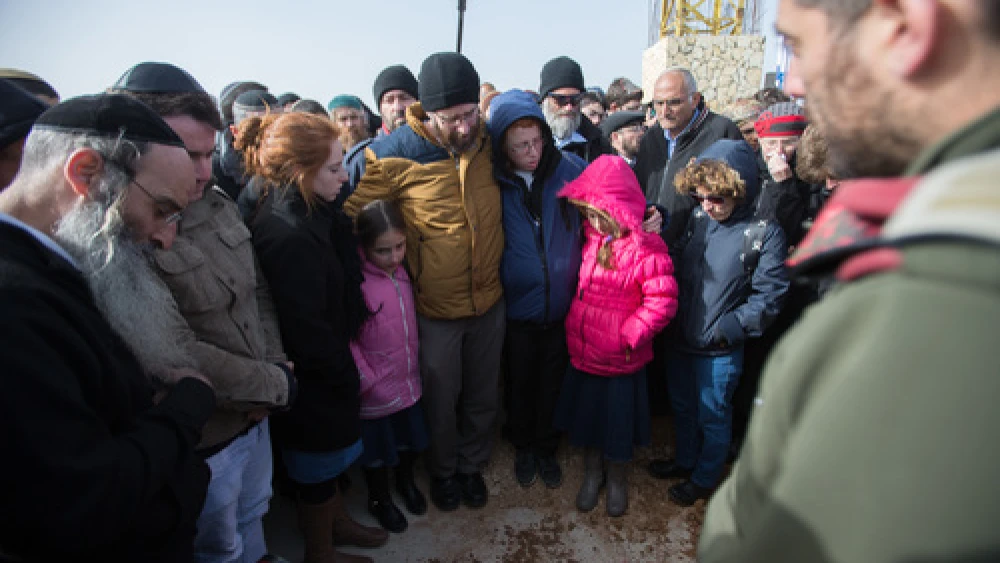 Click photo to download. Caption: In center, the husband and children of Israeli victim of terror Dafna Meir look down at her fresh grave during her funeral in Jerusalem on Jan. 18. Credit: Yonatan Sindel/Flash90.