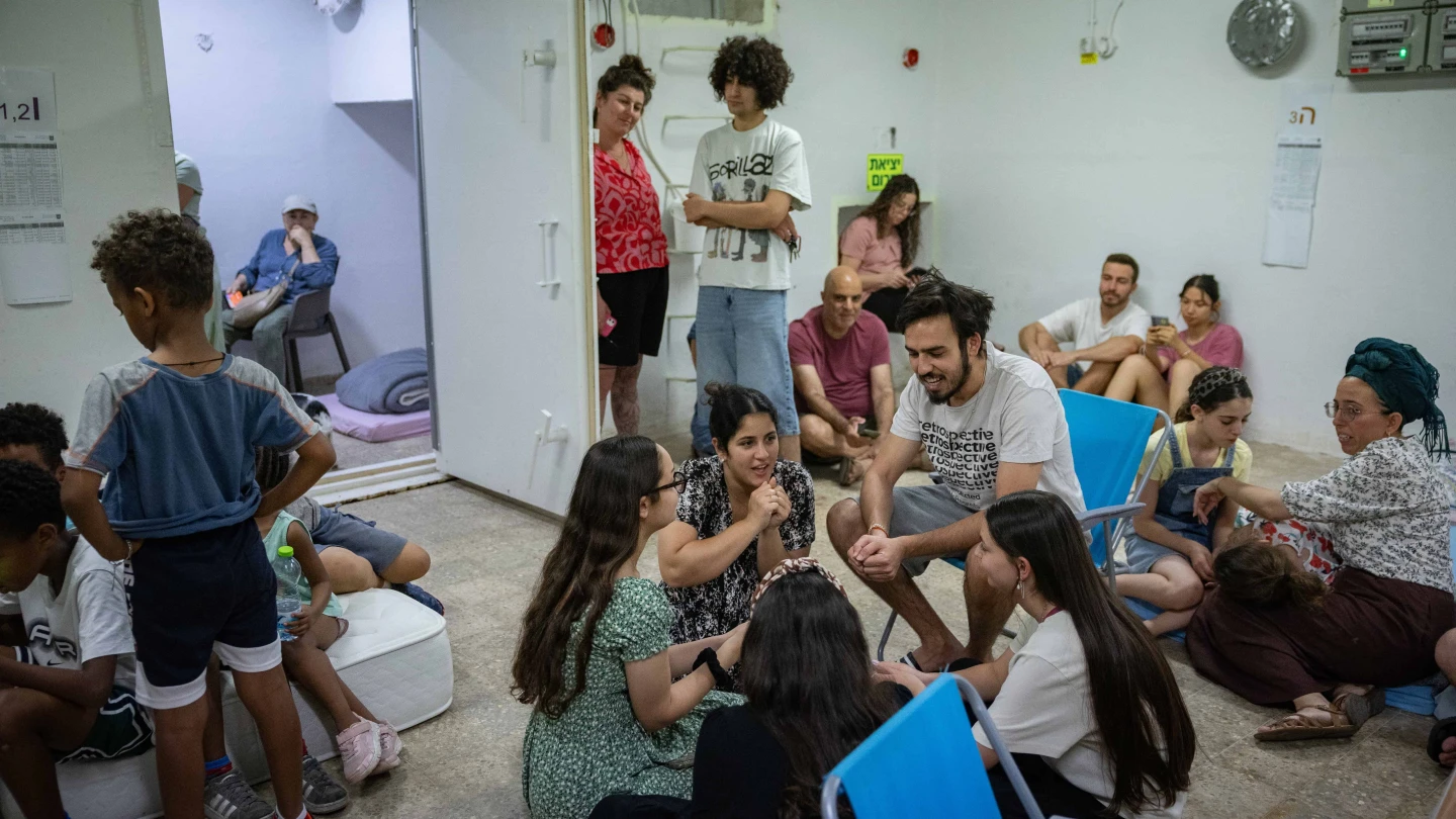 People take cover as siren warns of incoming missiles fired from Iran at a public bomb shelter in Jerusalem, June 20, 2025. Photo by Noam Revkin Fenton/Flash90.