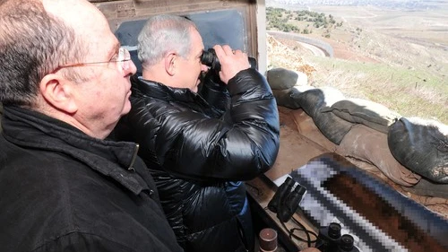 Israeli Minister of Defense Moshe Ya'alon (left) and Prime Minister Benjamin Netanyahu (center, with binoculars) survey the Israeli-Syrian border in the strategically significant Golan Heights region on Feb. 18, 2014. Credit: Ariel Hermoni/Ministry of Defense/FLASH90.