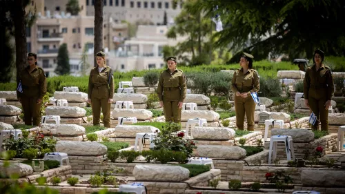 Soldiers place flags on the graves of fallen comrades at Mount Herzl Military Cemetery in Jerusalem, April 23, 2023. Photo by Yonatan Sindel/Flash90.