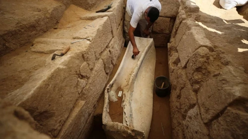 A Palestinian archaeologist works on a 2,000 year-old lead sarcophagus discovered during the excavation of a Roman cemetery in the northern Gaza Strip, July 16, 2023. Photo by Majdi Fathi/TPS.
