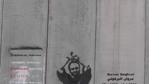 A portrait of Palestinian terrorist Marwan Barghouti on the security fence between Israel and the disputed territories. Credit: Eman via Wikimedia Commons.