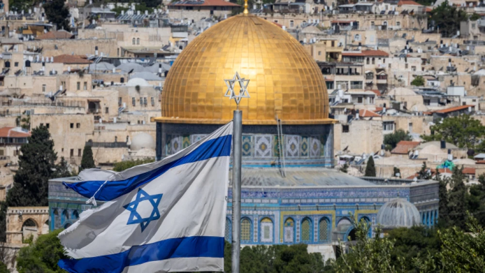 An Israeli flag, with the Dome of the Rock in Jerusalem's Old City in the background, as seen from the Mount of Olives observatory, on April 24, 2023. Photo by Yonatan Sindel/Flash90.