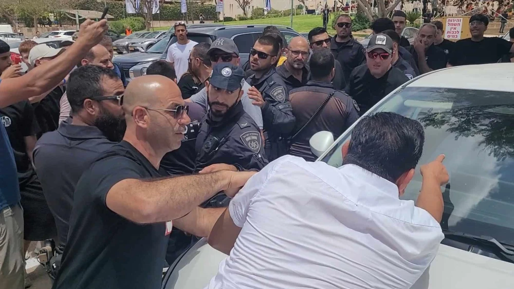 Protesters surround a car where Yair Golan sits ahead of his address at a conference in Be'er Sheva, Israel on may 27, 025. Photo by Canaan Lidor.