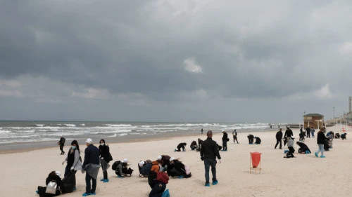 Israelis clean tar off the Bat Yam beach following an offshore oil spill that drenched most of the Israeli coastline, March 2, 2021. Photo by Tomer Neuberg/Flash90.