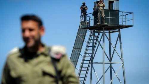 A Lebanese soldier and a Hezbollah gunman gaze into Israel from a watchtower on the border near Rosh Hanikra, Sept. 5, 2018. Photo by Basel Awidat/Flash90.