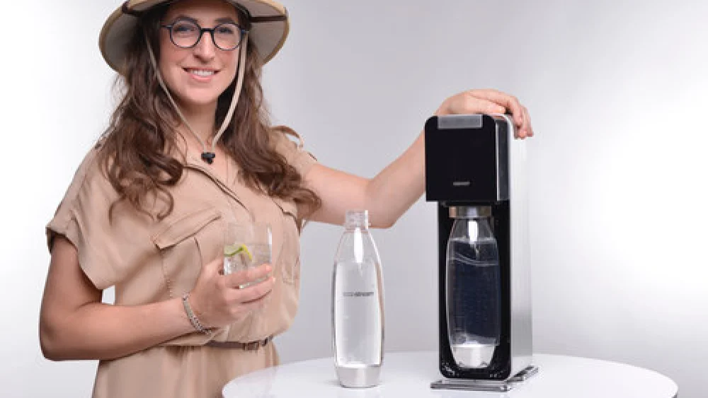 Mayim Bialik, star of the “Homoschlepiens” video campaign, with a SodaStream machine. Credit: SodaStream.