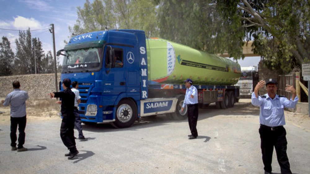 Palestinian security officers stand guard as Egyptian trucks carrying fuel drive down a street after entering the Gaza Strip from Egypt, June 21, 2017. Credit: Abed Rahim Khatib/Flash90.
