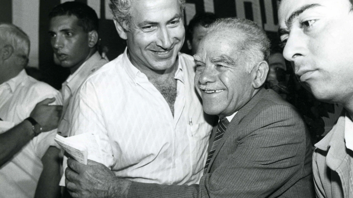 Former Prime Minister Yitzhak Shamir (right) laughs with current Prime Minister Benjamin Netanyahu at a Likud Party meeting in 1986. Photo by Moshe Shai/Flash90.