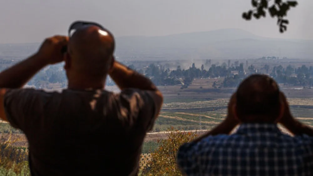 Israelis in the northern Golan Heights region watch smoke rise in Syria in September 2014. Credit: Flash90.