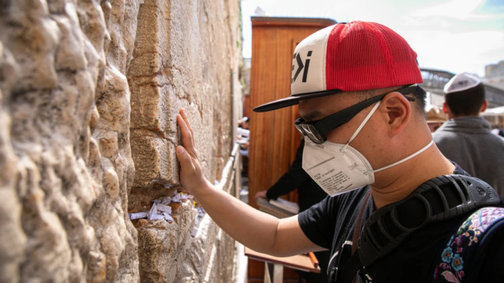An American tourist wears a face mask to protect against germs while prayering at the Western Wall in the Old City of Jerusalem on Feb. 27, 2020. Photo by Olivier Fitoussi/Flash90.