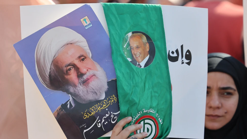A woman holds pictures of Hezbollah leader Naim Qassem (left) and Lebanese Parliament Speaker Nabih Berri on April 30, 2026. Photo by Anwar Amro/AFP via Getty Images.