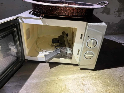 A gun in a microwave was one of the weapons found by the IDF's Samaria Regional Brigade on Nov. 19, 2025. Photo: IDF.