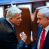 Opposition leader Yair Lapid, then the foreign minister, walks past Prime Minister Benjamin Netanyahu, at the time the leader of the opposition, at the Knesset in Jerusalem, Nov. 8, 2021. Photo by Olivier Fitoussi/Flash90.