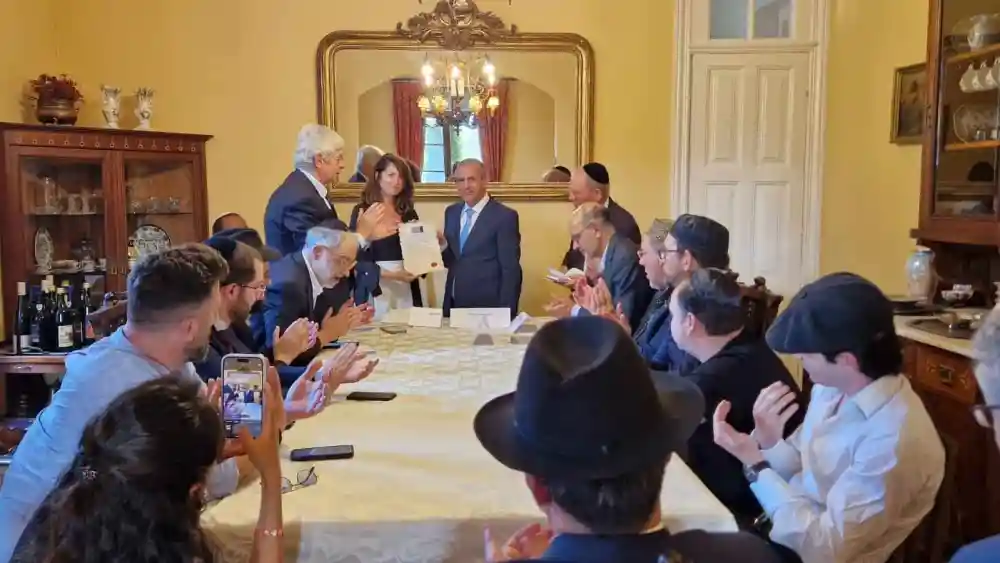 Shira Granot, director of community engagement at the Combat Antisemitism Movement, receives the tribute to the Mukhariq initiative on behalf of CAM from Luis Eduardo Afonso Andrade, president of the International Observatory for Human Rights. Credit: Courtesy.