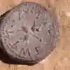 A 2,000-year-old coin discovered at the entrance to a cave in the Judean Desert, bearing an inscription reading "Holy Jerusalem" in ancient script. Credit: Emil Aladjem/IAA.