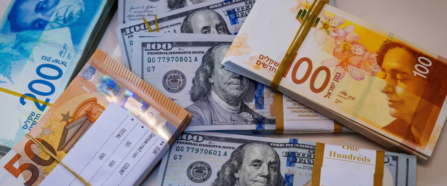 Illustration of U.S. $100 bills, 100 and 200 Israeli shekel bills, and 50 European euro bills, May 19, 2025. Photo by Nati Shohat/Flash90.