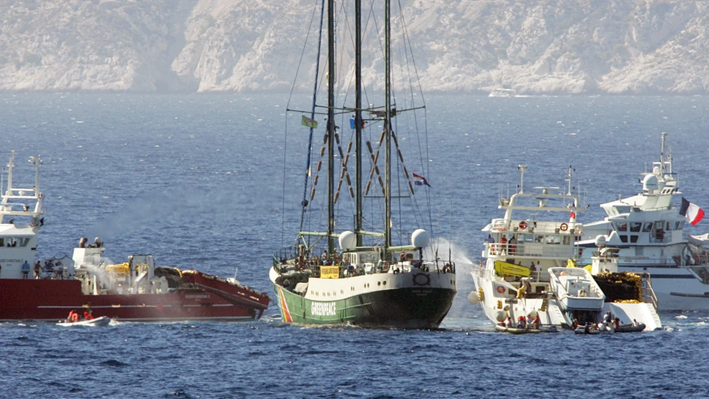 Greenpeace's Rainbow Warrior II (center with masts) is enircled by tuna fishing vessels to prevent it from docking, as it tries to move into Marseille's harbor, Aug. 23, 2006. Photo by Boris HORVAT / AFP) (Photo by BORIS HORVAT/AFP via Getty Images)