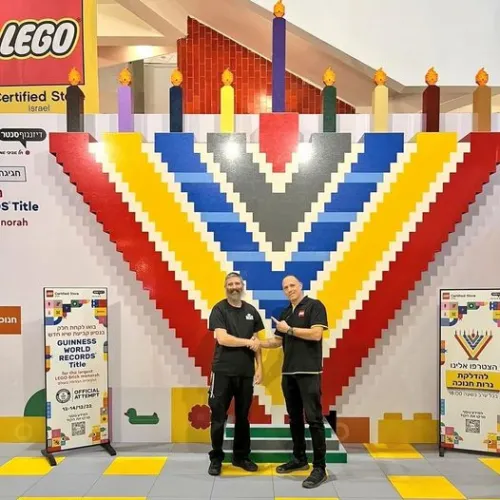 The massive LEGO menorah with Yitzchok Kasowitz (left), founder of Jbrick, and the manager of LEGO Store Tel Aviv. Source: Courtesy of Yitzchok Kasowitz.