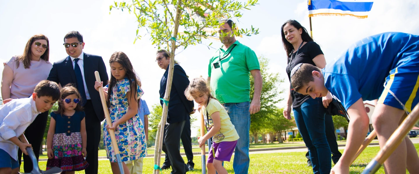 A tree planting ceremony on Coushatta tribal lands, including Consul General of Israel to the Southwest U.S. Gilad Katz (third from right, wearing green) and his family. Credit: Alyssa Wallace.