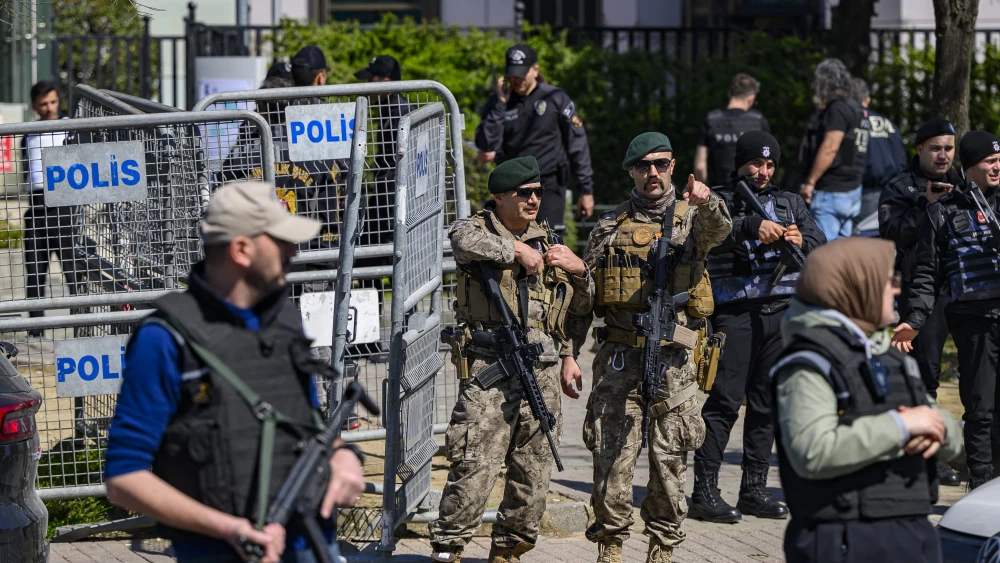 A police official gestures as he stands alert near The Israeli Consulate in Istanbul on April 7, 2026, following a shootout between gunmen and police. One gunman was killed and two others were wounded in a shootout with police outside the Israeli consulate in Istanbul, the local governor said, adding two officers were lightly wounded. Photo by Yasin Akgul / AFP via Getty Images.