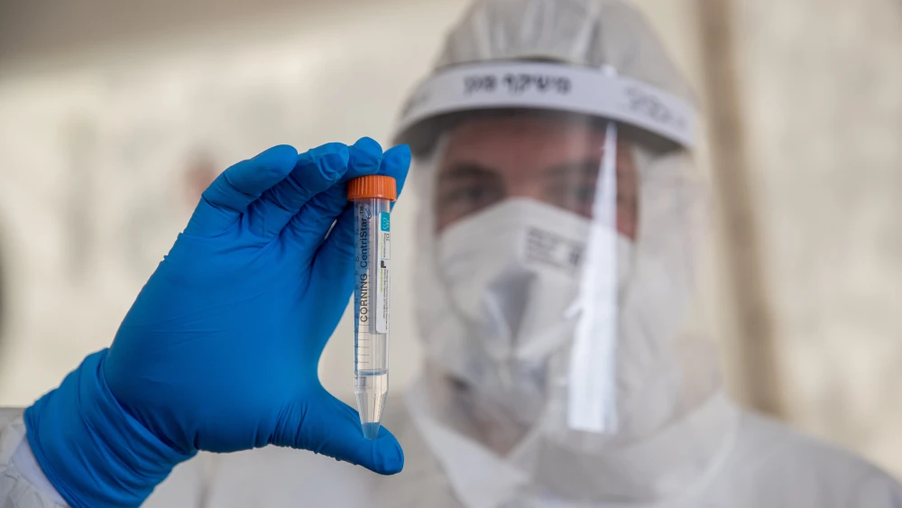 A Magen David Adom medical worker collects samples for coronavirus testing at the entrance to the East Jerusalem village of Jabel Mukaber, April 2, 2020. Photo by Yonatan Sindel/Flash90.