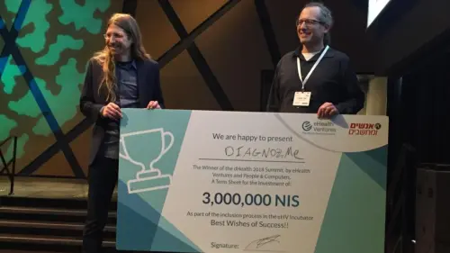Diagnoz.me founders Ariel Livne and Tamir Epstein accepting their NIS 3 million (nearly $830,000) prize money at the dHealth 2018 Summit. Credit: Courtesy of Israel21c.