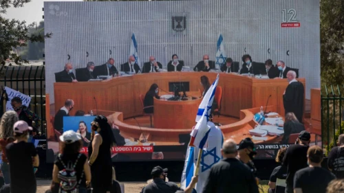 Israelis watch a Supreme Court session on petitions filed against the proposed unity government, outside the Knesset in Jerusalem, on April 3, 2020. Photo by Yonatan Sindel/Flash90.