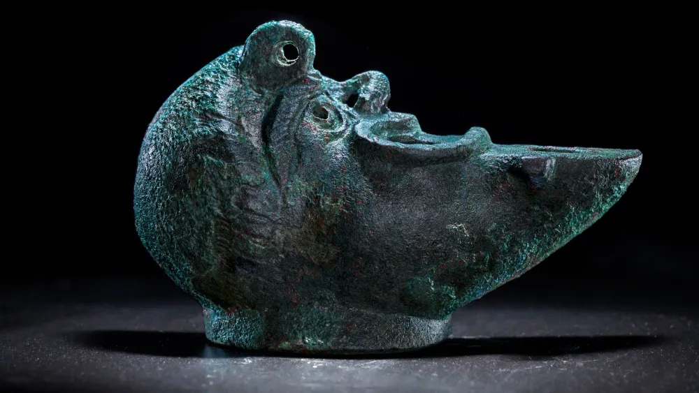 A rare bronze oil lamp, shaped like a grotesque face cut in half, was recently discovered during excavations in Jerusalem’s City of David National Park. May 5, 2021. Credit: Israel Antiquities Authority.