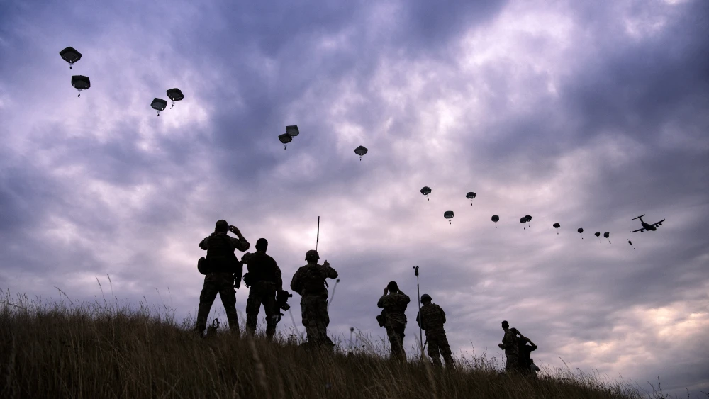 NATO paratroopers drop out of a U.S. Air Force Hercules during the 'Swift Response 17' joint airborn military exercise at Bezmer airfield near the village of Bezmer, Bulgaria on July 18, 2017. Photo by DIMITAR DILKOFF/AFP via Getty Images.