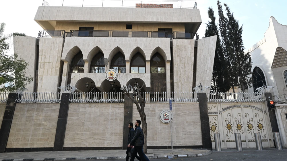 Men walk past the UAE Embassy in the capital Damascus on December 12, 2024. Photo by Louai Beshara/AFP via Getty Images.