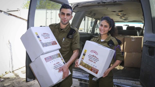 Representatives of IDF units hold food products donated by residents in the surrounding communities in Gush Etzion that will be giving away later to families of IDF soldiers, in Gush Etzion, in Judea and Samaria, on March 28, 2017, ahead of the Jewish holiday of Passover. Photo by Gershon Elinson/Flash90.