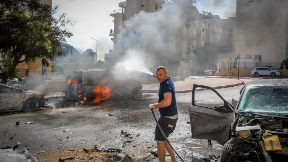 A man works to extinguish a fire ignited by a Gazan rocket strike in Ashkelon, Oct. 7, 2023. Photo by Jamal Awad/Flash90.