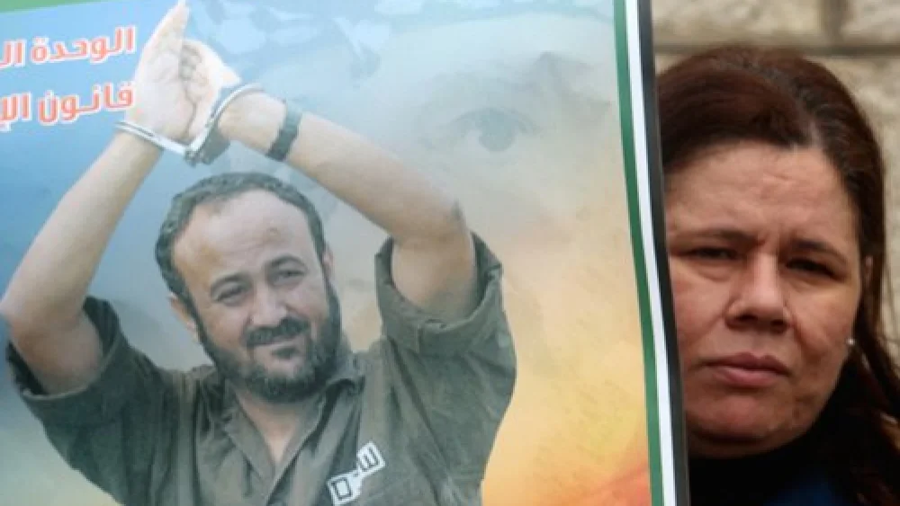A Palestinian woman holds a portrait of Palestinian terrorist prisoner Marwan Barghouti during a rally in Ramallah, the headquarters of the Palestinian Authority, on March 27, 2012. Credit: Issam Rimawi/Flash90.