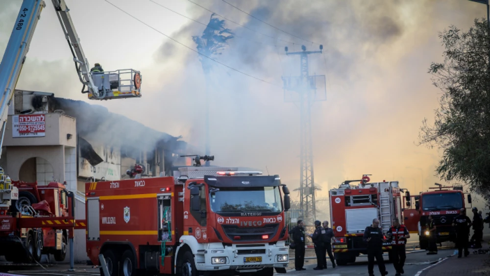 Israeli firefighters work to extinguish a fire at a factory in the town of Sderot caused by a rocket fired from the Gaza Strip, Nov. 12, 2019. Photo by Noam Revkin Fenton/Flash90.