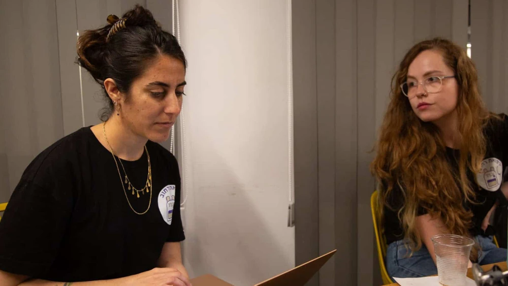 Ronnie-Lee Sneh (left) discusses strategy with another volunteer at a team briefing. Credit: Courtesy of Street Medicine Tel Aviv.